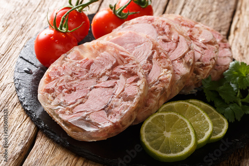 Homemade head cheese or brawn with fresh tomatoes, lime and cilantro close up. horizontal photo