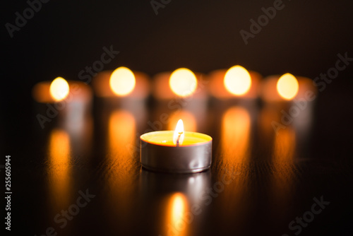 Candle close-up on the background of blurred burning candles