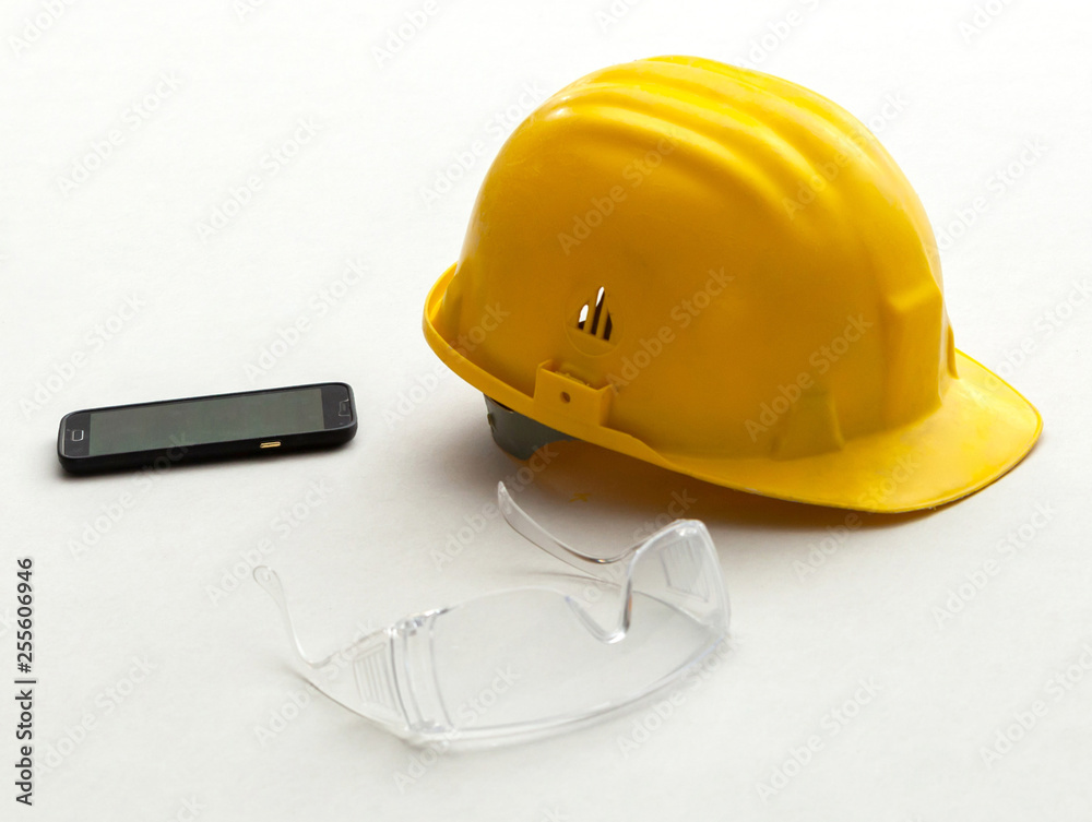 Yellow helmet, protective glasses and mobile phone. Yellow helmet, protective glasses and mobile phone.