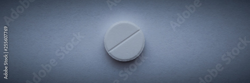 One white large pill on a dark blue background.