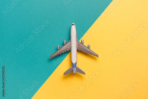 Flat lay airplane on yellow and blue background