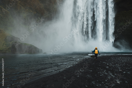 woman looking at picturesque waterfall, Iceland. Nordic nature