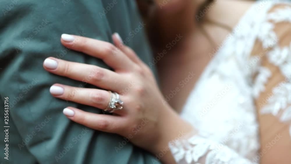 Close up of wedding ring on finger of bride holding grooms arm. Close up of wedding ring on finger of bride holding grooms arm.