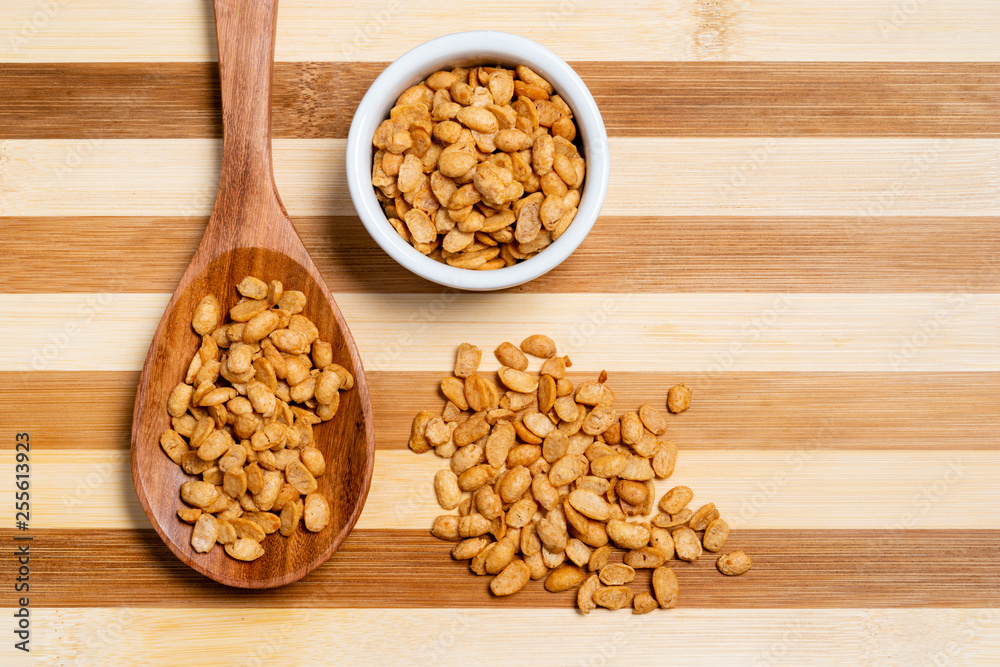 Roasted soybeans in wooden spoon and pot on bamboo striped table. Roasted soybeans in wooden spoon and pot on bamboo striped table.