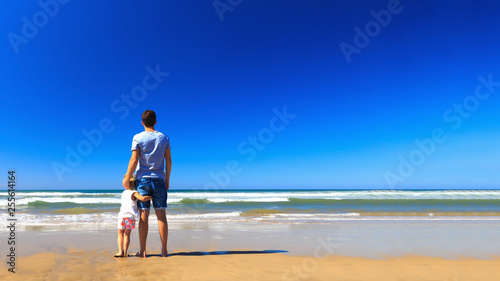 Father and daughter have fun on the seashore.