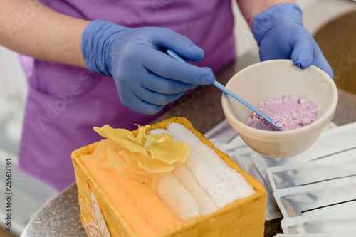 Closeup photo of cosmetologist's hands mixing ingredients for peeling mask