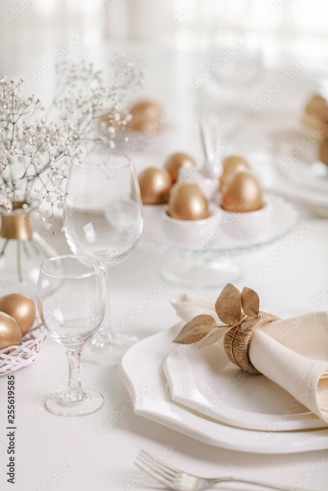 Happy Easter! Golden decor and table setting of the Easter table with white dishes of white color. Happy Easter! Golden decor and table setting of the Easter table with white dishes of white color.