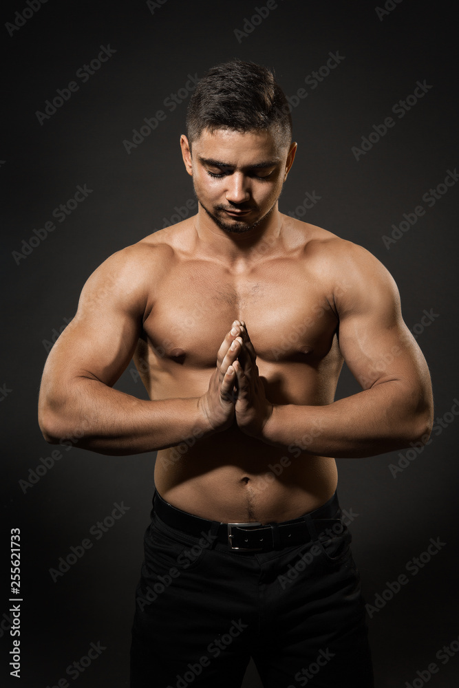 Athlete Man Studio Portrait, Sexy Sportsman Naked Body Concentrating with Folded Hands over Black Background