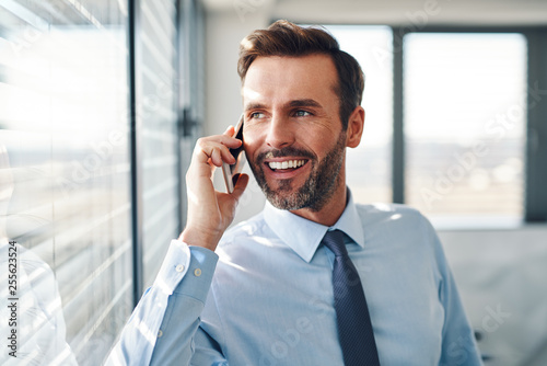 Handsome businessman talking on phone in modern office