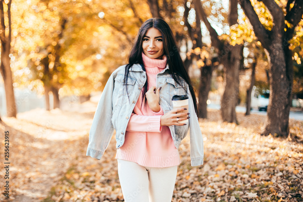 Beautiful woman drink coffee and walking in the park.