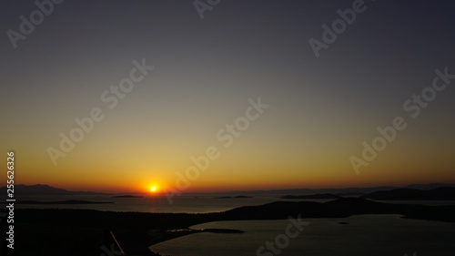 Blazing sunset over Aegean Sea  Ege Denizi  in Seytan Sofrasi  Devil s Table   Ayvalik  Turkey. Bright dramatic sky  dark ground. Scenic colorful sky at sunset landscape. Sun over skyline  horizon.