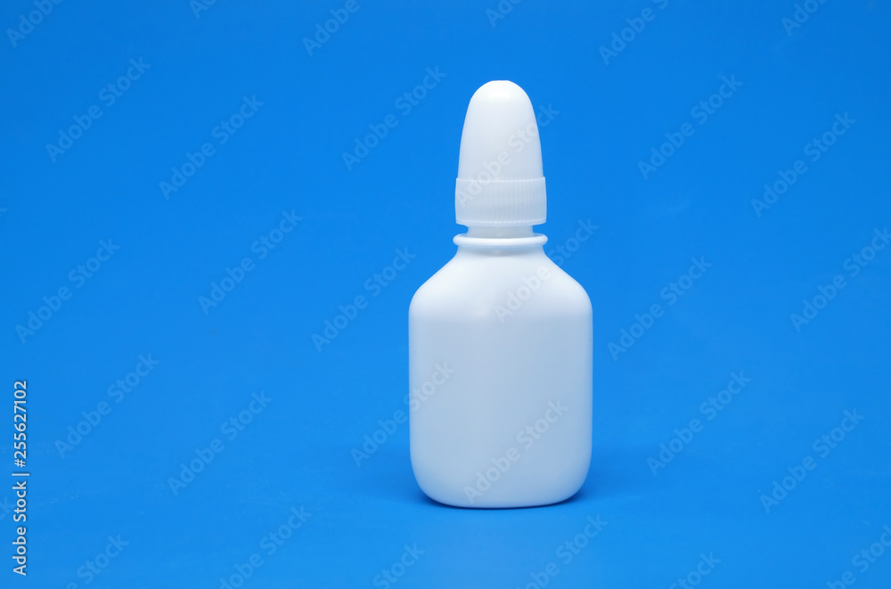 Nasal spray and dropper isolated on blue background.
