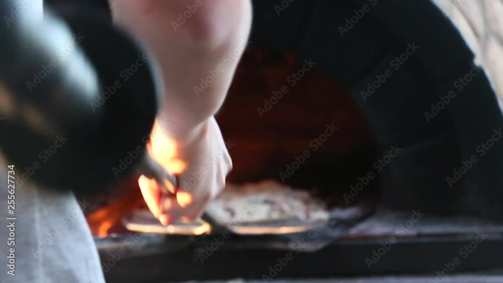 Putting a homemade pizza into a wood fired pizza oven. Putting a homemade pizza into a wood fired pizza oven.