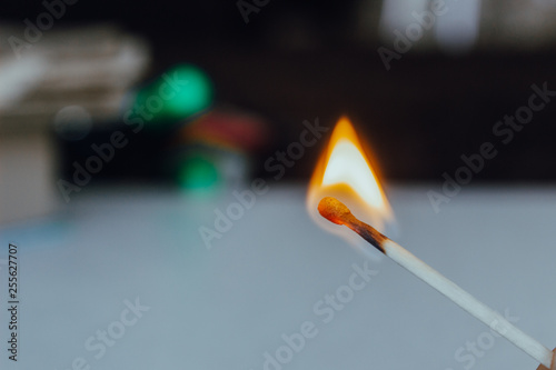 a lit match on a light background