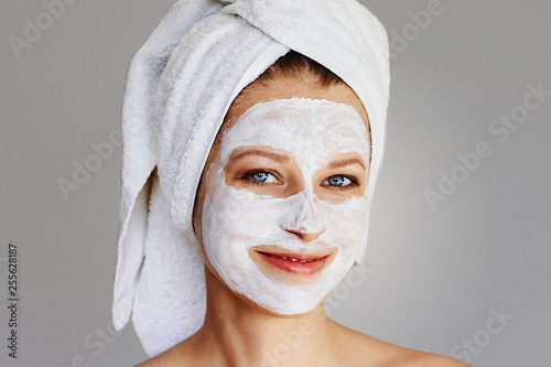 Beautiful young woman with facial mask on her face. Skin care and treatment  spa  natural beauty and cosmetology concept.