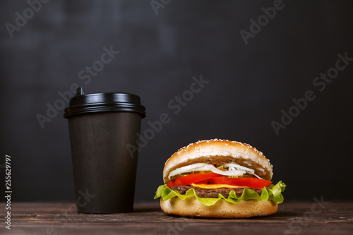 Wallpaper Mural Beef Burger with bacon and coffee in a black paper Cup on a wooden table on a dark background. Cafe menu design concept Torontodigital.ca