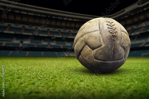 Vintage football ball on the grass field in stadium