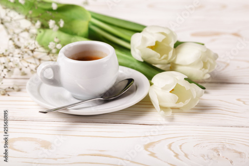 Spring tulips and coffee on a white wooden background close-up. Mother's day background, women's day, morning Birthday