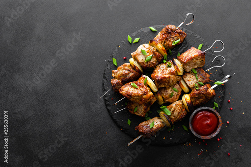 Grilled meat skewers, shish kebab on black background, top view photo