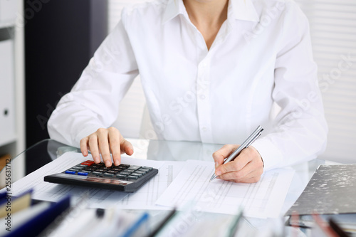 Unknown bookkeeper woman or financial inspector making report, calculating or checking balance, close-up. Business portrait. Audit or tax concepts