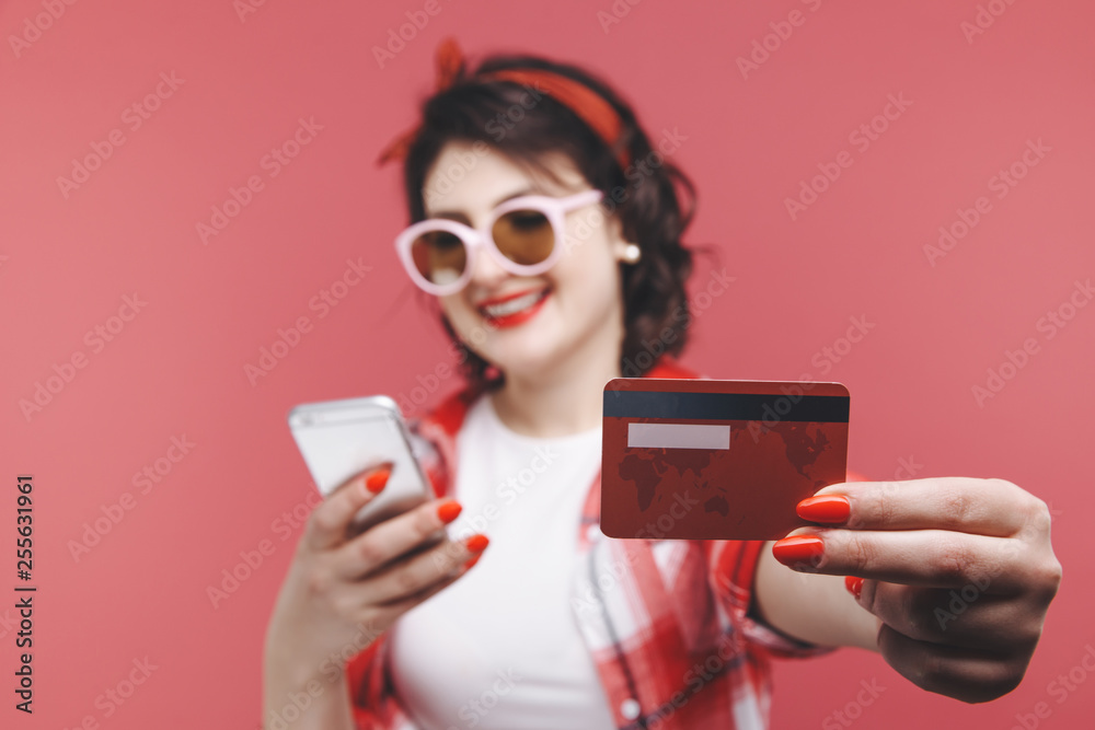 Image of excited young lady isolated over pink background using mobile phone holding credit card. Image of excited young lady isolated over pink background using mobile phone holding credit card.