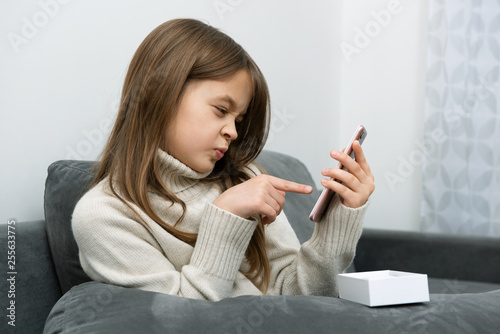 The girl is showing finger in a smartphone.