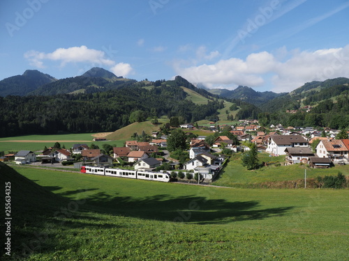 Alpine panorama with houses and modern train at european Gruyeres town in Switzerland on August