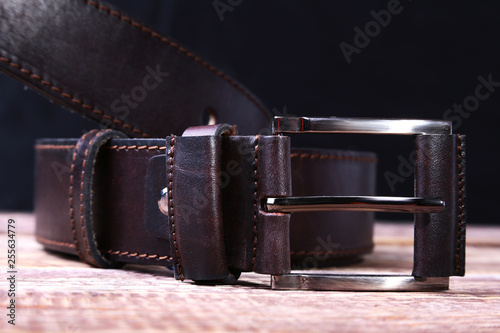 Men elegance leather belt on wooden table.