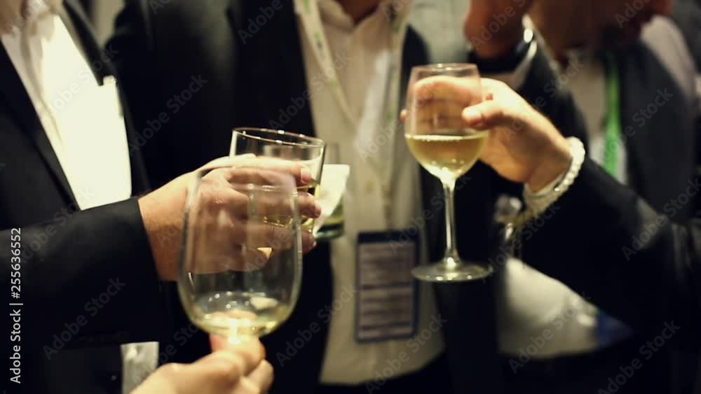 People celebrating & giving cheers touching glasses in teamwork corporate event wearing formal suit clothing. People celebrating & giving cheers touching glasses in teamwork corporate event wearing formal suit clothing.