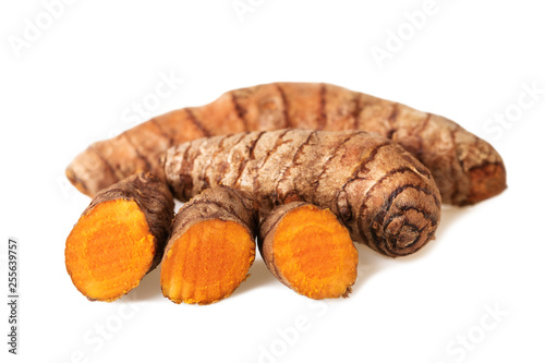 Turmeric roots whole and slices on white