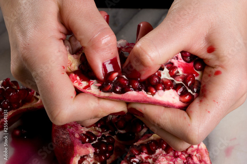 woman hands opening a pomagranate