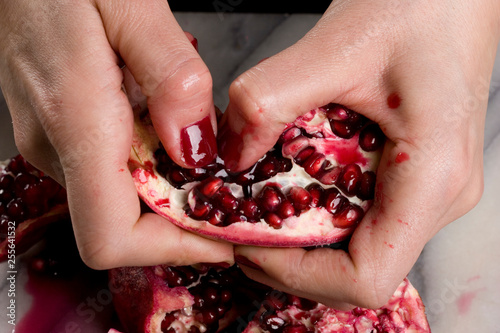 woman hands opening a pomagranate