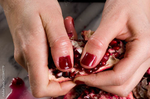woman hands opening a pomagranate