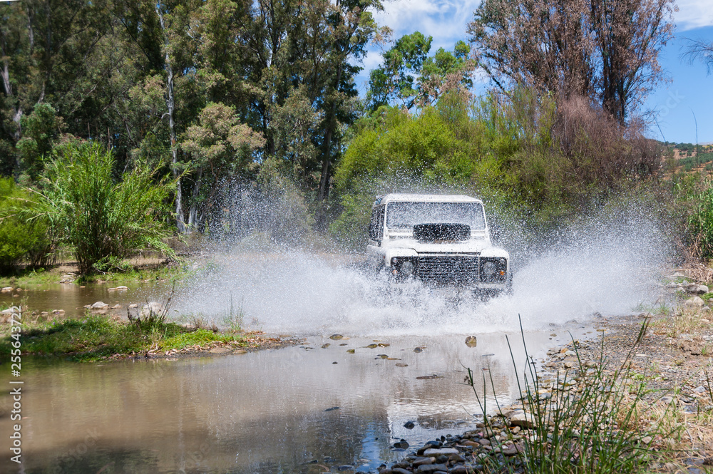 Rural Andalucia, Andalusia. Spain. 4x4 vehicle crossing river causing water splashes. Front view.