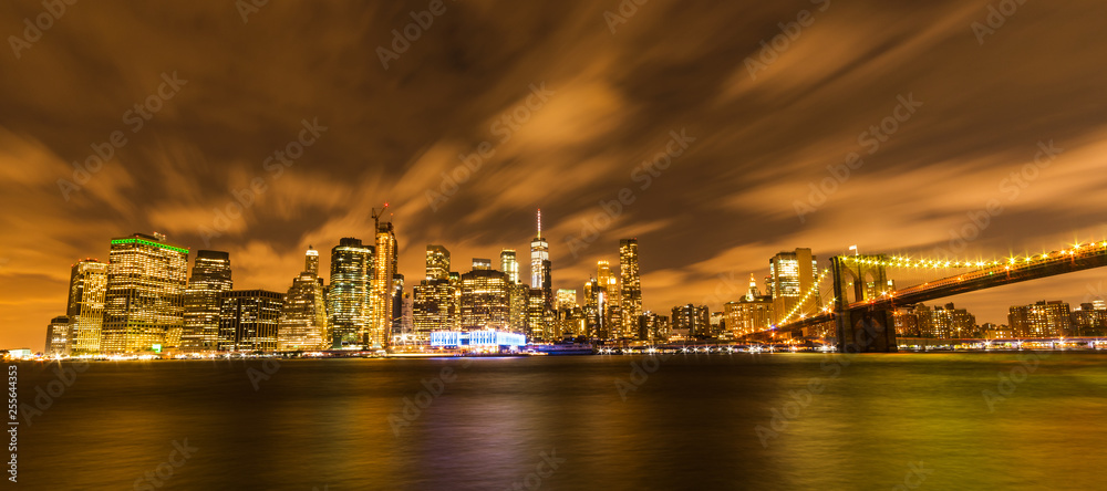 Manhattan panoramic skyline at night with Brooklyn Bridge. New York City, USA. Office buildings and skyscrapers at Lower Manhattan (Downtown Manhattan).
