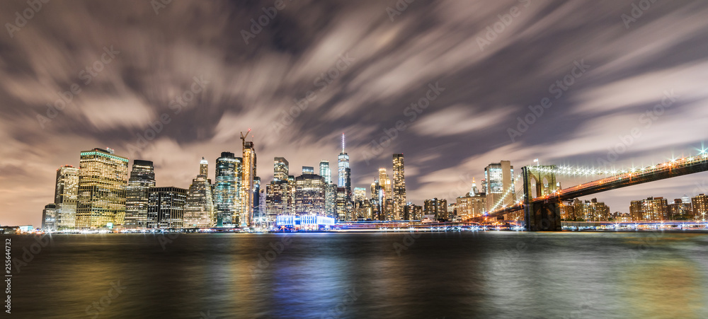 Manhattan panoramic skyline at night with Brooklyn Bridge. New York City, USA. Office buildings and skyscrapers at Lower Manhattan (Downtown Manhattan).