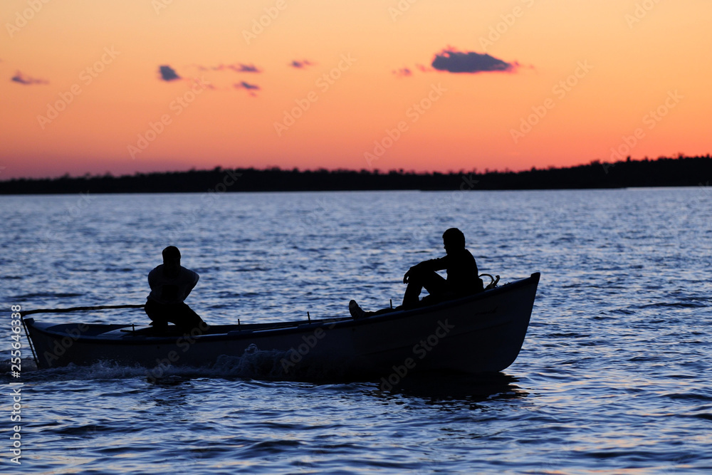 Naklejka premium Wooden boat on sunset 