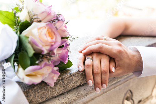 Young married couple holding hands on wedding day, love and happiness