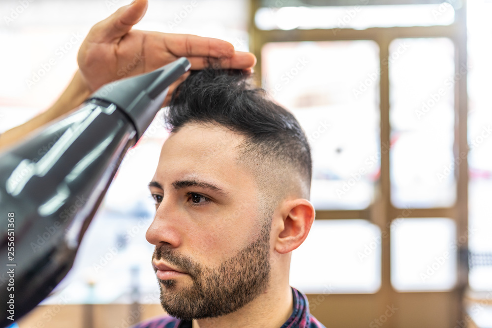 Young Man Getting a Hairstyle in a Barbershop.
