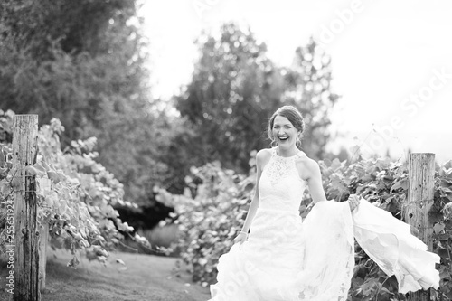 Laughing bride holding wedding dress
