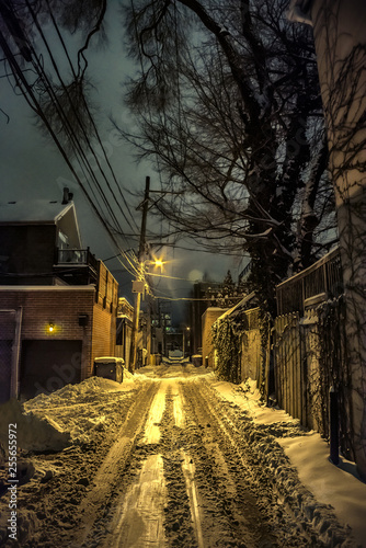 Dark urban Chicago city alley with snow and ice in the winter at night