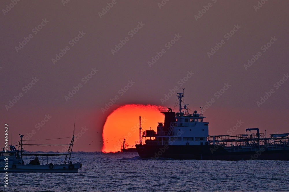 Obraz premium 明石海峡に沈むダルマ夕日の情景