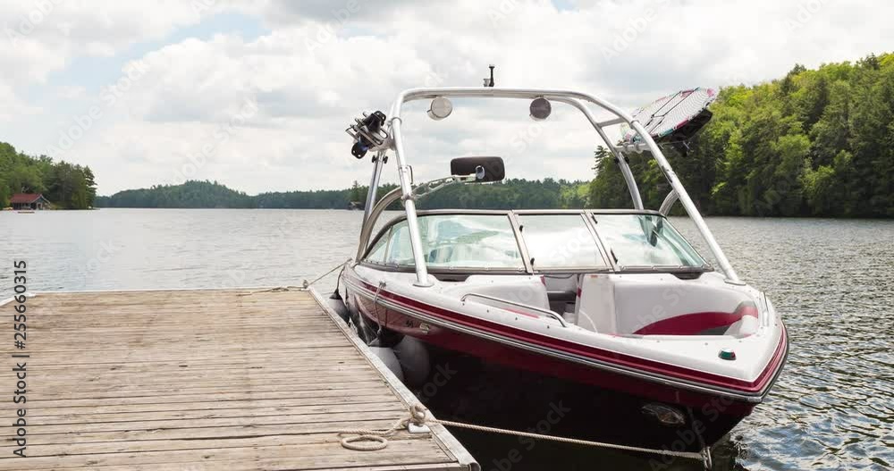 An animated picture of a wakeboard boat at a wooden dock in the Muskokas on a sunny day. An animated picture of a wakeboard boat at a wooden dock in the Muskokas on a sunny day.