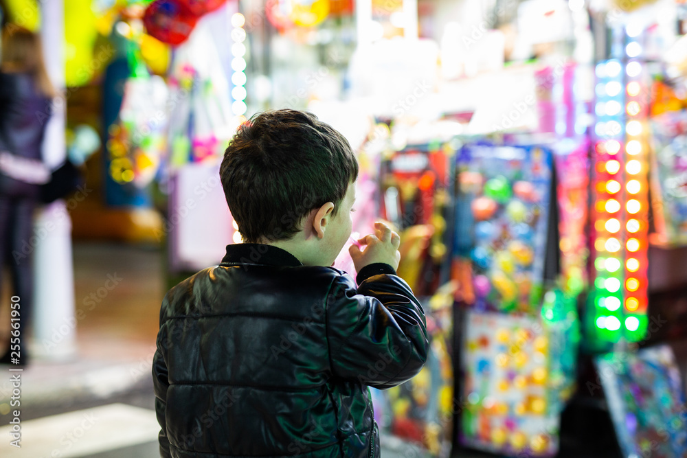 Obraz premium boy eats cotton candy at the fair