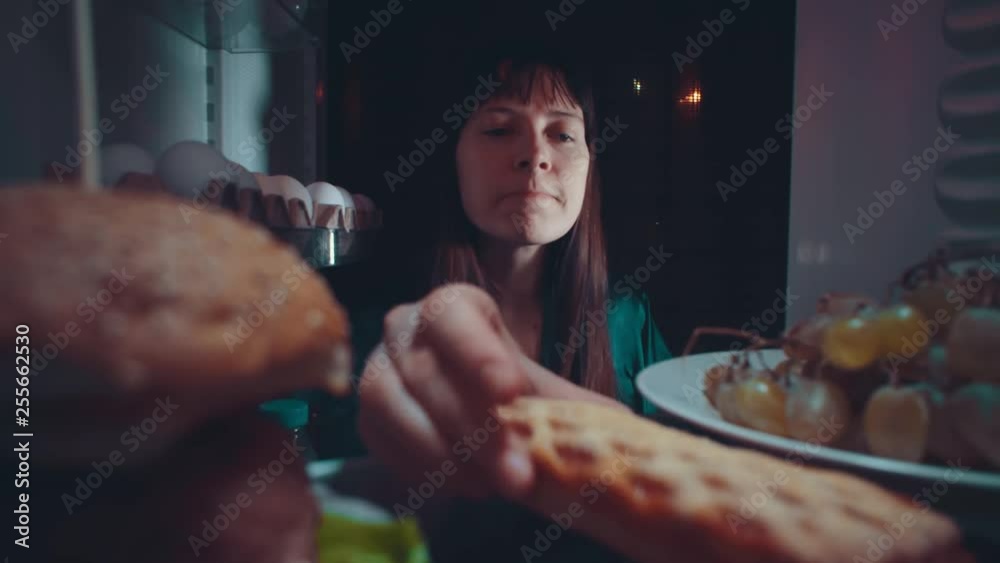 Little cute baby takes food out of the refrigerator at night, the ...