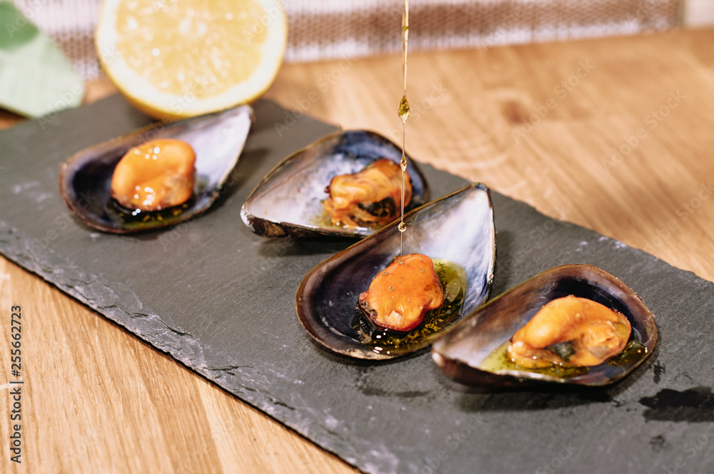 Steamed mussels on slate table and wooden table