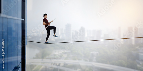 Brave ropewalker on cable. Mixed media photo