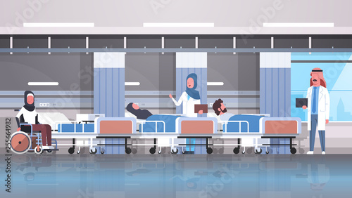 arabic doctors team visiting disabled arab patients sitting wheelchair lying bed intensive therapy ward healthcare concept hospital clinic room interior horizontal
