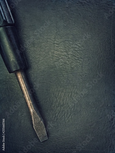 Old screwdriver on a black background.