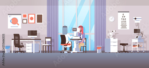 arab ophthalmologist checking patient vision arabic doctor in hijab and uniform making eye surgery laser correction medicine and healthcare concept oculists office interior horizontal